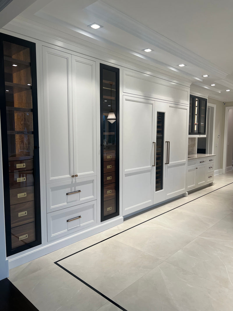 Luxury custom built-in cabinetry featuring integrated refrigeration, glass display cabinets, wine storage, and floor-to-ceiling millwork by Cambridge Kitchens.