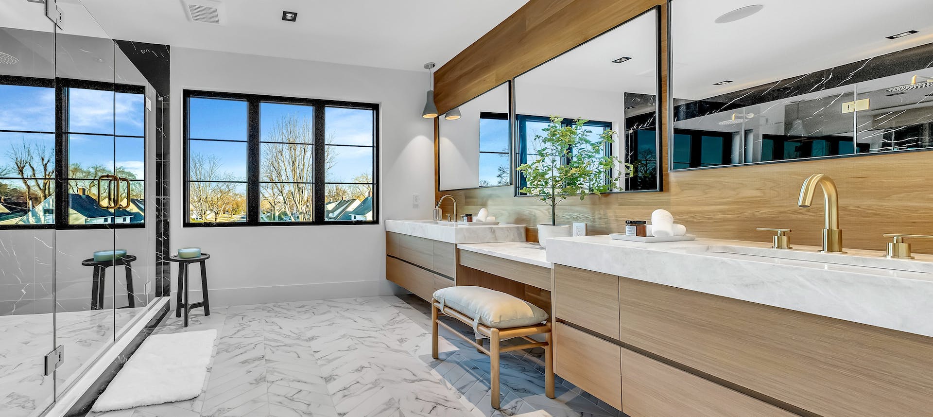 Luxury custom white oak bathroom vanity with floating cabinetry, integrated makeup station and modern wood wall paneling by Cambridge Kitchens on Long Island.