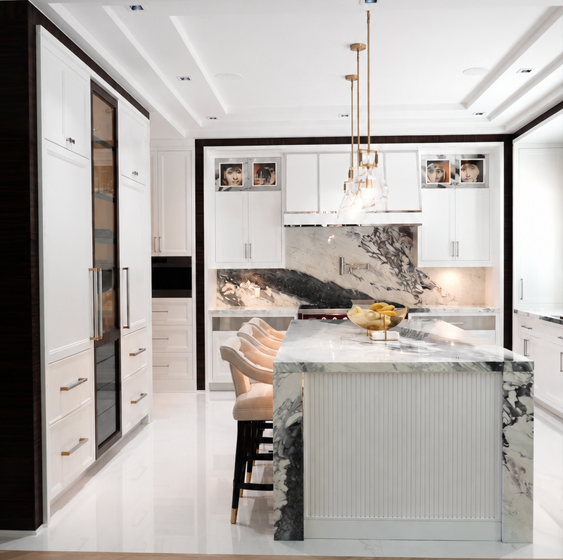 Luxury white custom kitchen cabinetry with dark wood accents, glass display cabinets and a fluted island, designed by Cambridge Kitchens on Long Island.