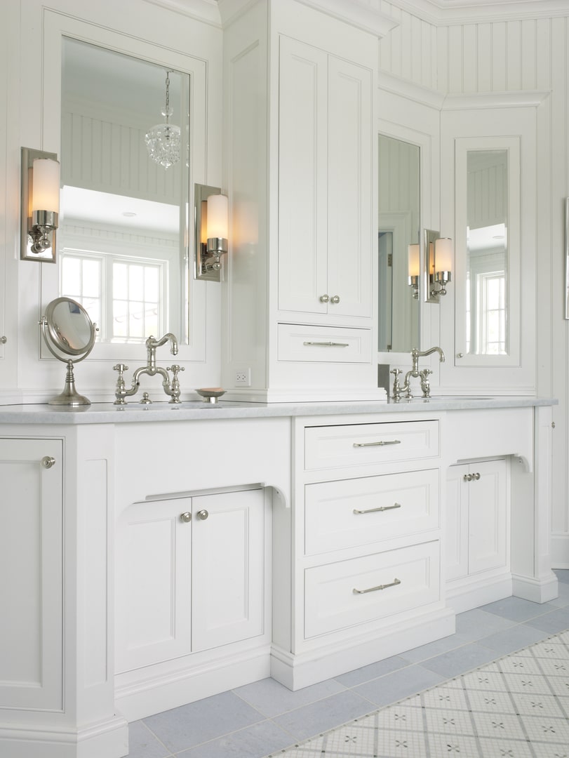 Transitional white custom bathroom vanity with inset cabinetry, integrated storage, framed mirrors and architectural millwork by Cambridge Kitchens on Long Island.